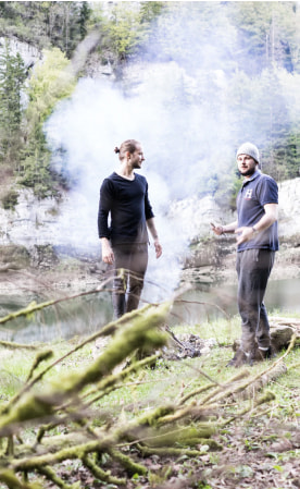 Двое мужчин стоят перед озером.