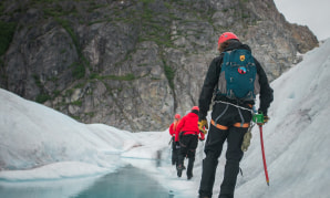 Группа людей, идущих по заснеженной тропинке.